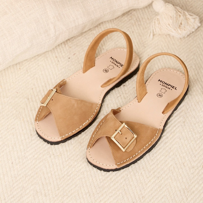 Leather menorquina sandal with buckle in leather color, perspective view on a carpet - MONPIEL