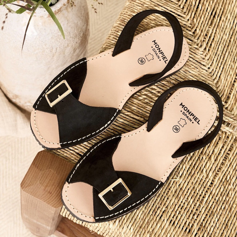 Black menorquina sandal with buckle, top view, tilted on a chair - MONPIEL