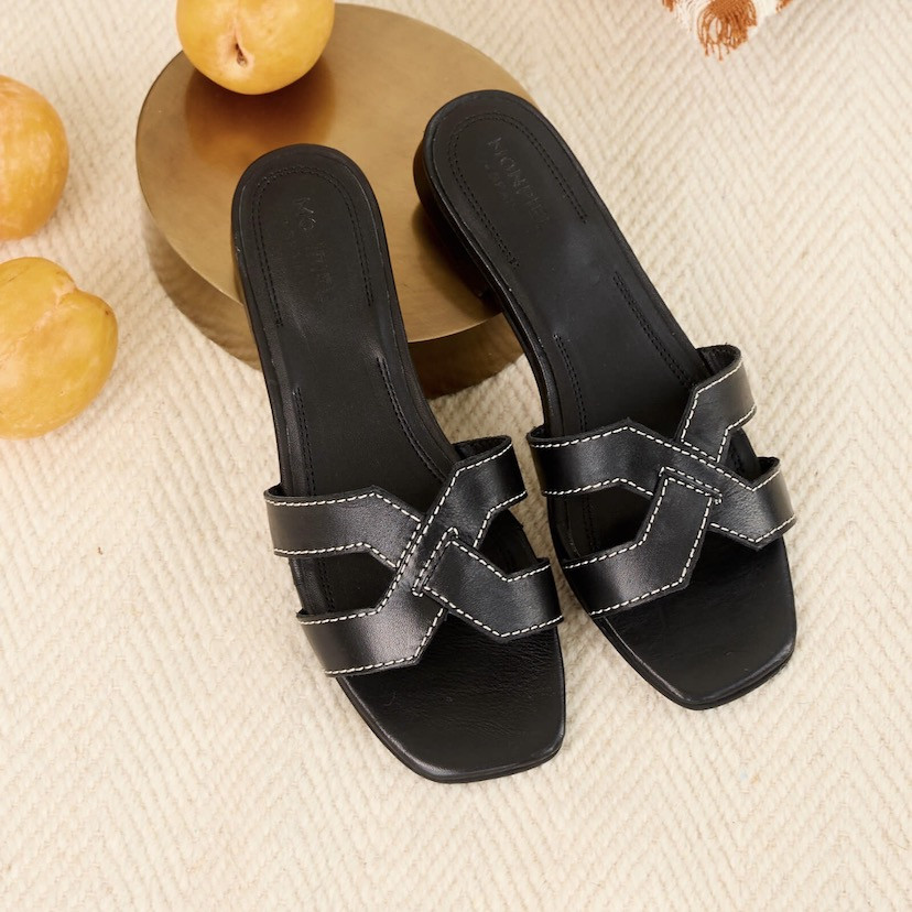 Leather menorquina sandal with buckle in leather colour, perspective view, feet resting on a cushion - MONPIEL