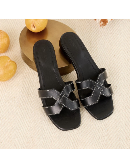 Black leather Carmina slide sandal with a top-down view, heel resting on a base - MONPIEL Black leather Carmina slide sandal with a top-down view, heel resting on a base - MONPIEL