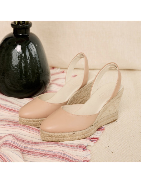 Nude-farbene Leder-Espadrille mit Keilabsatz, Perspektivansicht auf Teppich, Vase dahinter - MONPIEL