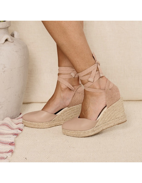 Espadrille em couro com cunha Elba em tom nude, vista lateral ao lado de um vaso - MONPIEL Espadrille em couro com cunha Elba em tom nude, vista lateral ao lado de um vaso - MONPIEL