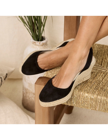 Black suede wedge espadrilles with crossed feet on a chair - MONPIEL