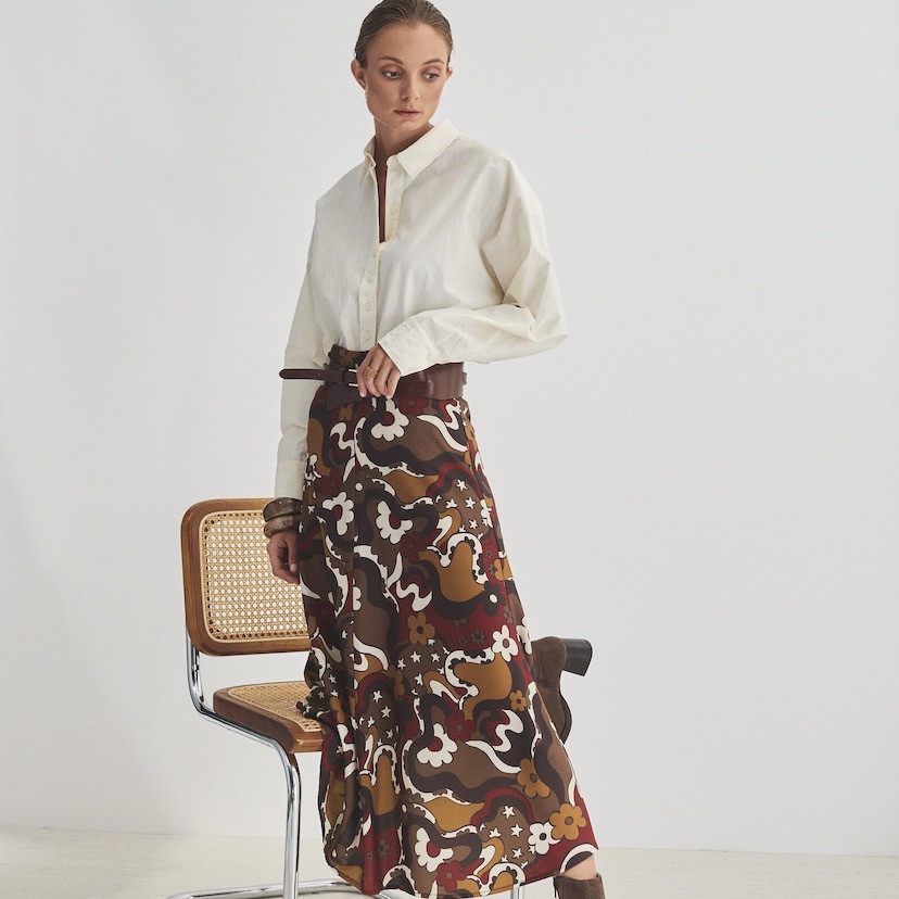 Wide Havana leather belt on a printed skirt, hand resting on the belt - MONPIEL