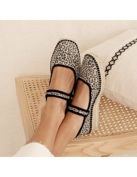 Schwarze Leopard-Canvas-Mary-Jane-Espadrille mit gekreuzten Füßen auf einer Bank - MONPIEL