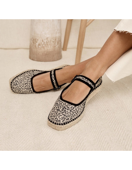 Schwarze Leopard-Canvas-Mary-Jane-Espadrille mit gekreuzten Füßen auf einem Teppich - MONPIEL