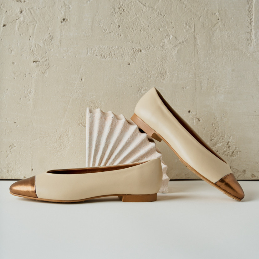 Ameliè flat ballerina with metallic beige/copper toe, side profile view, heel resting on decoration - MONPIEL