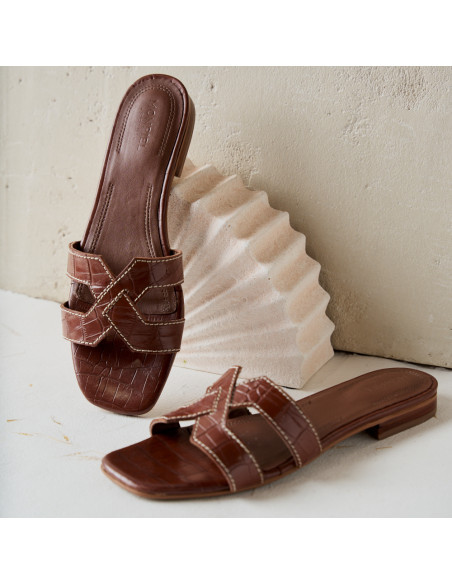 Sandalo Carmina in pelle color cuoio effetto coccodrillo, vista prospettica e frontale appoggiata su decorazione - MONPIEL Sandalo Carmina in pelle color cuoio effetto coccodrillo, vista prospettica e frontale appoggiata su decorazione - MONPIEL