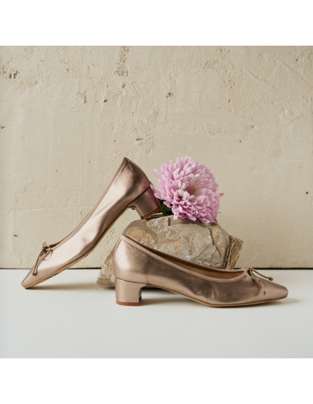 Manuela ballerina con fiocco e tacco in colore cappuccino bronzo, vista di profilo, tacco appoggiato su una roccia con - MONPIEL