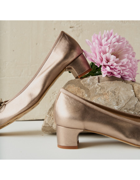 Manuela ballerina con fiocco e tacco in colore cappuccino bronzo, vista di profilo, tacco appoggiato su una roccia con - MONPIEL