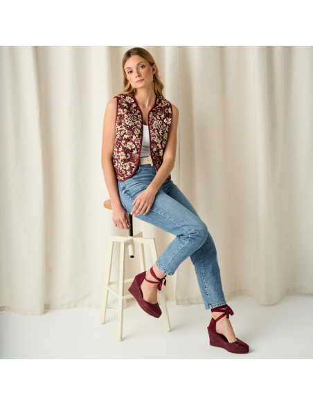 Creta bordeaux wedge espadrilles com modelo sentada em um banco, plano geral - MONPIEL Creta bordeaux wedge espadrilles com modelo sentada em um banco, plano geral - MONPIEL