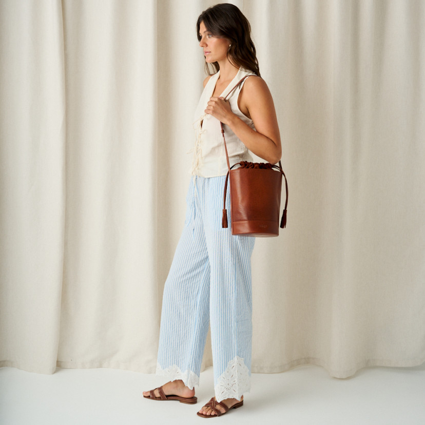 Carmina leather toe-post sandal in coco leather, perspective view of feet, model in profile, full shot - MONPIEL