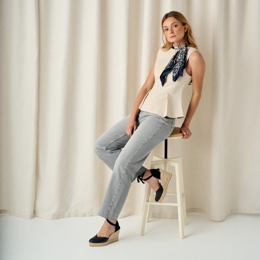 Elba leather wedge espadrille in black, side view on stool, full shot of model - MONPIEL
