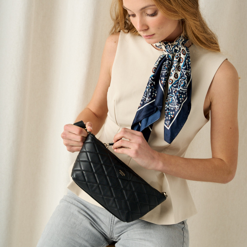 Bolsa de couro feminina pequena acolchoada New York em preto com detalhe de zíper frontal em plano médio - MONPIEL