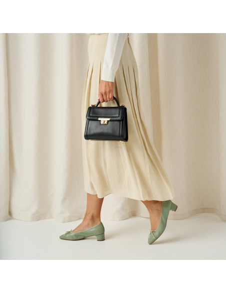 Small black leather 60's handbag for women, medium shot with model in profile, detail of ballerina steps - MONPIEL