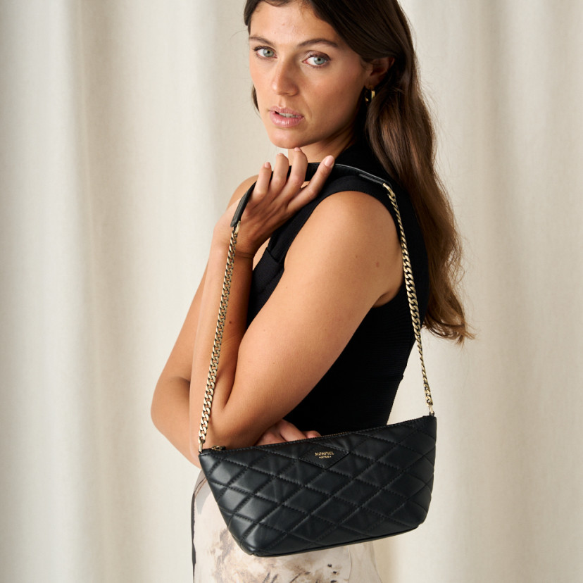 Small black leather quilted New York handbag for women, front view, hanging on shoulder - MONPIEL