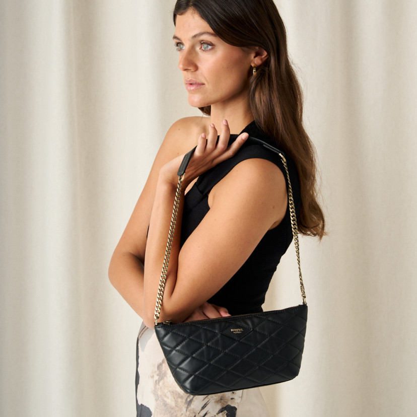 Small black leather quilted New York handbag for women, front view, hanging on shoulder, close-up - MONPIEL