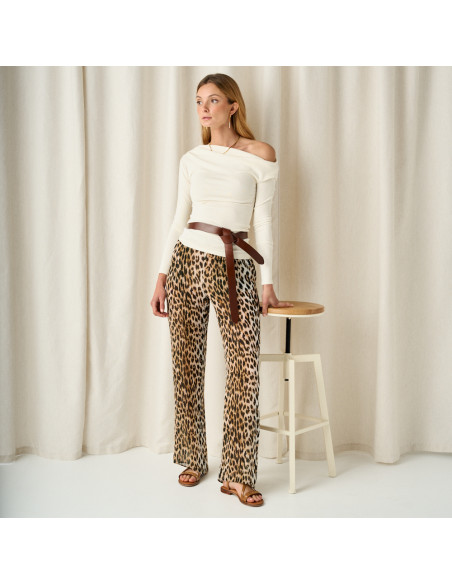 Bari studded cross strap sandal in tan color, general shot with leather belt at waist, leaning on stool - MONPIEL