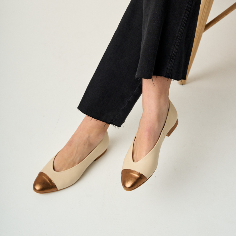 Ameliè flat ballerina with metallic beige/copper toe cap, crossed legs in close-up, perspective view - MONPIEL