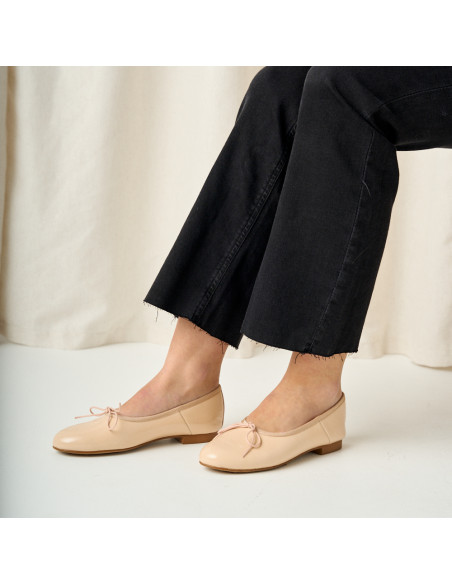 High-cut nude patent leather ballet flat, side view with feet resting on the ground - MONPIEL High-cut nude patent leather ballet flat, side view with feet resting on the ground - MONPIEL