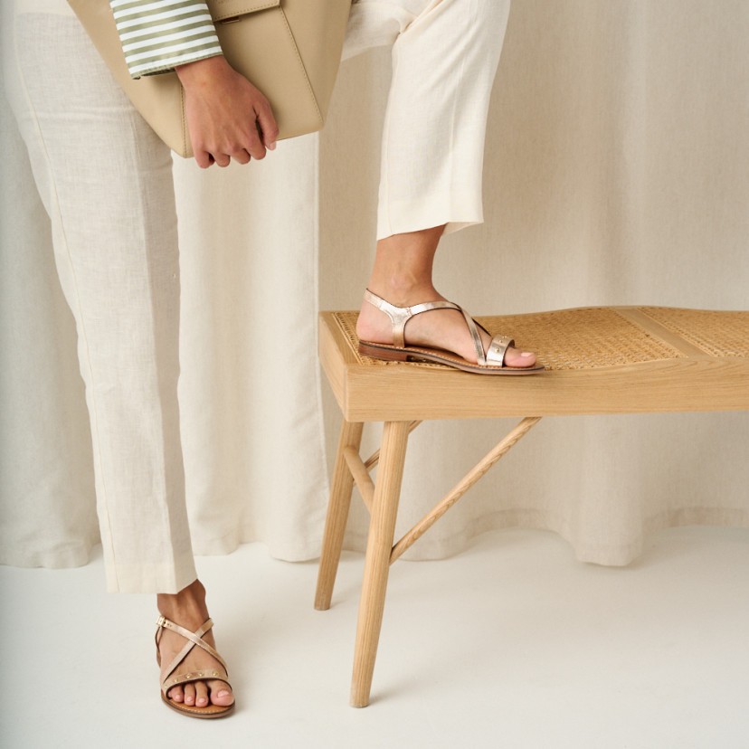 Bari crossed studded sandal in platinum with front and side view, foot resting on bench - MONPIEL