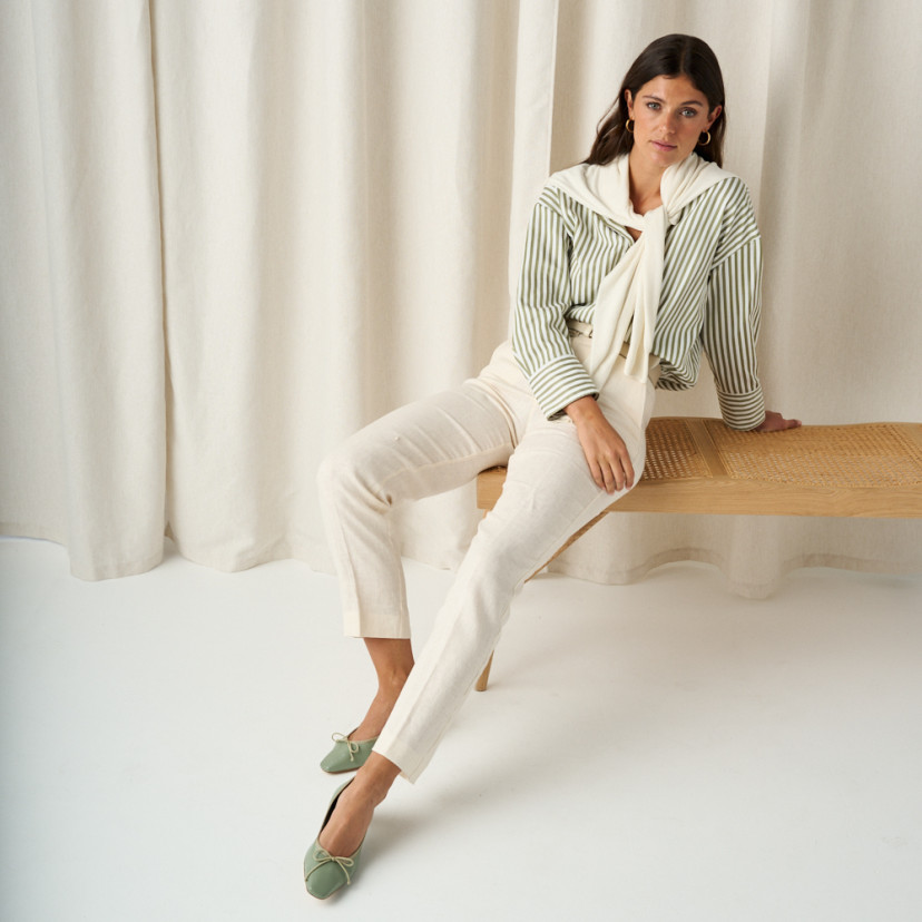 Manuela low heel bow flat slipper in mint green, full shot of the model sitting on the bench - MONPIEL