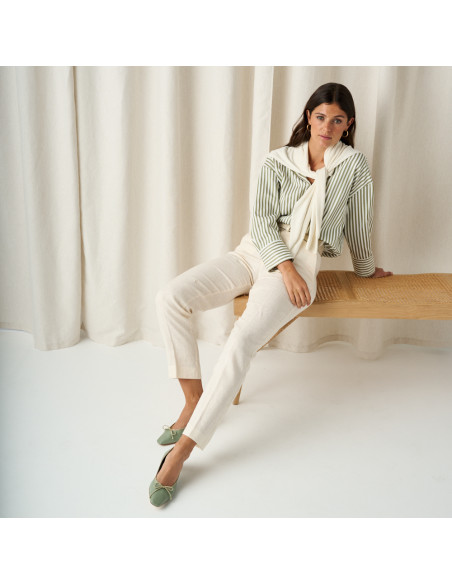 Manuela low heel bow flat slipper in mint green, full shot of the model sitting on the bench - MONPIEL
