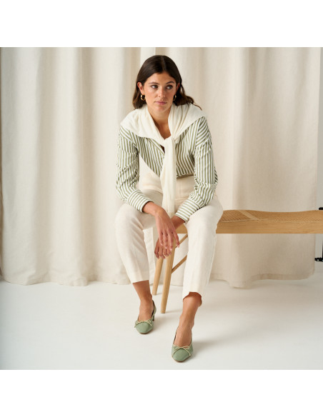 Mint green ballerina with small bow heel, front view, full shot of the model sitting on the bench with arms resting - MONPIEL