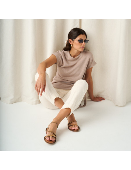 Amalfi buckle sandal in leather colour, full shot of the model sitting on the floor with crossed feet and sunglasses - MONPIEL Amalfi buckle sandal in leather colour, full shot of the model sitting on the floor with crossed feet and sunglasses - MONPIEL
