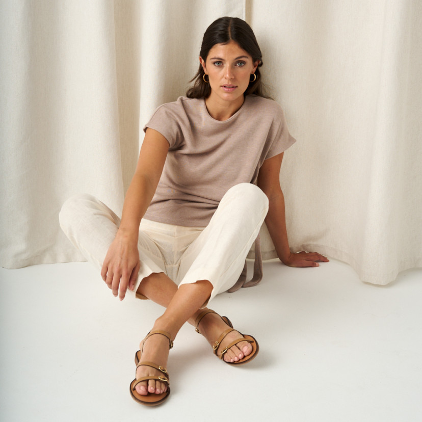 Amalfi buckle sandal in leather colour with front view and full shot of the model sitting on the floor - MONPIEL