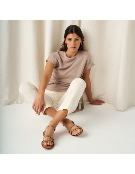Amalfi buckle sandal in leather colour with front view and full shot of the model sitting on the floor - MONPIEL Amalfi buckle sandal in leather colour with front view and full shot of the model sitting on the floor - MONPIEL