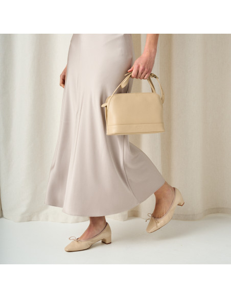 Sac moyen en cuir beige tenu par la poignée à la main - MONPIEL Sac moyen en cuir beige tenu par la poignée à la main - MONPIEL