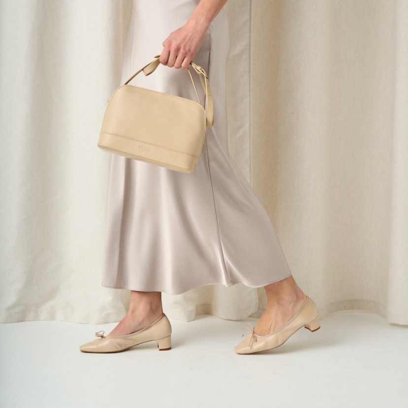 Medium leather bag in beige with front view walking - MONPIEL