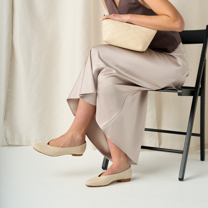 Flat slipper in beige with medium shot and model with crossed legs on chair in profile - MONPIEL