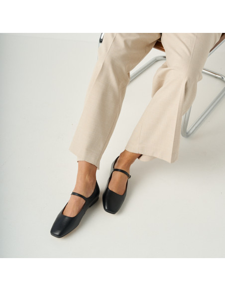 Mary Jane con cinturino Carlota color nero, vista dall'alto, modello seduto con pantaloni da completo - MONPIEL