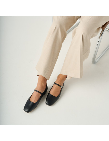 Carlota strap Mary Jane in black with top view, model sitting with suit trousers - MONPIEL Carlota strap Mary Jane in black with top view, model sitting with suit trousers - MONPIEL