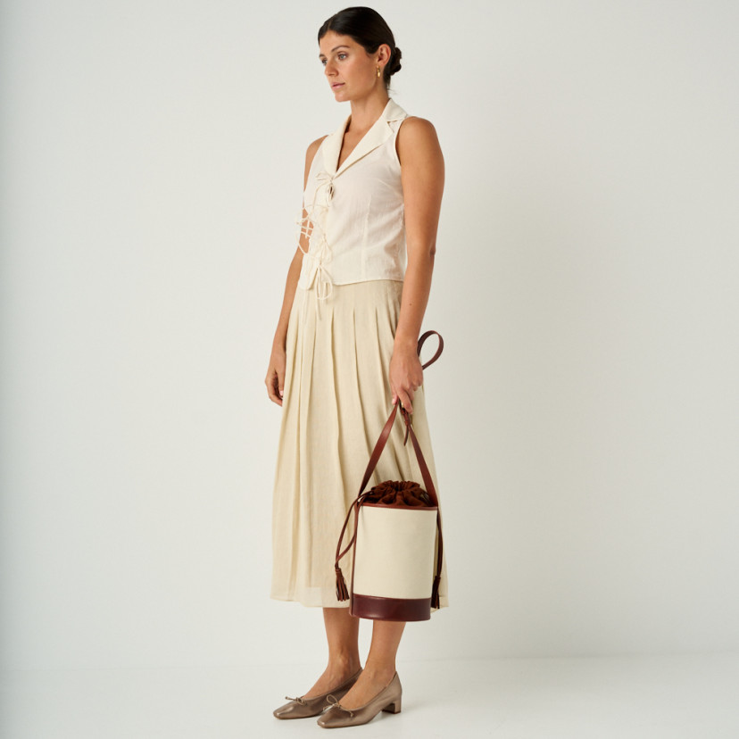Manuela low heel bow flat slipper in cappuccino bronze with perspective view and full shot with bucket bag in hand - MONPIEL