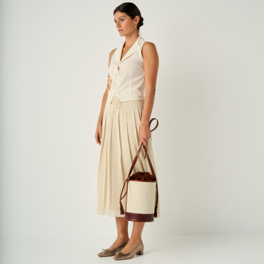 Canvas and leather bucket bag in black, front view, resting on a wall - MONPIEL 2