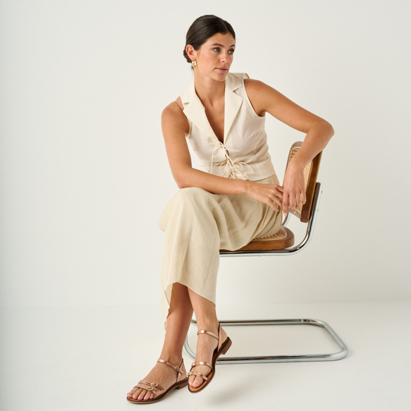 Amalfi buckle sandal in rose gold, full shot of the model sitting on the chair with crossed legs - MONPIEL