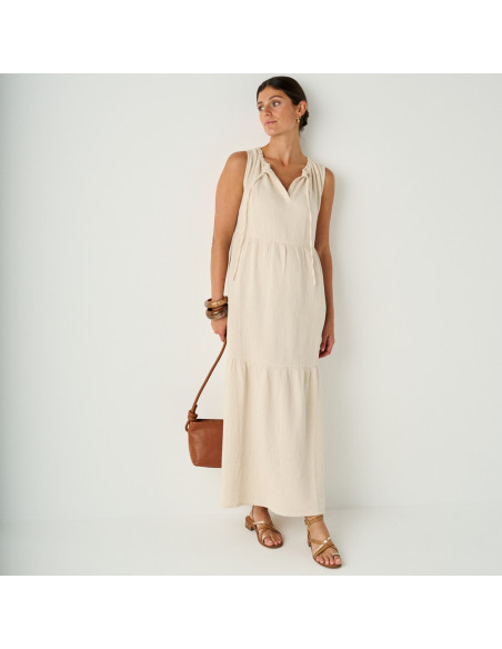 Platinum strap sandal with a small heel in leather color, general shot with a leather bag in hand - MONPIEL Platinum strap sandal with a small heel in leather color, general shot with a leather bag in hand - MONPIEL