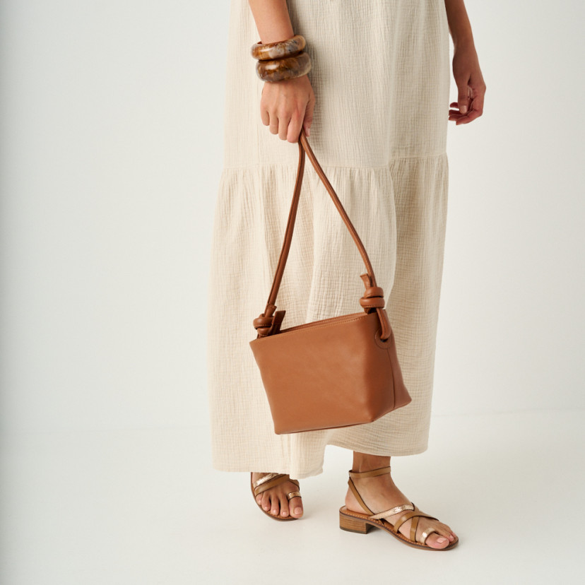 Rodios low heel platinum strap sandal in leather color, medium shot with leather bag hanging - MONPIEL