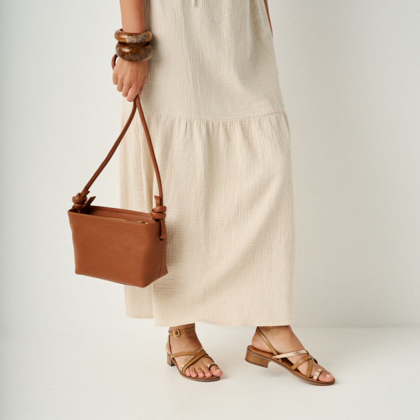 Rodios low heel platinum strap sandal in leather color, medium shot with leather bag hanging - MONPIEL