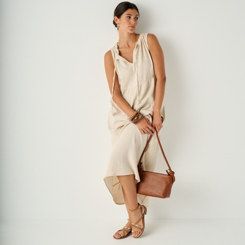 Rodios low heel platinum strap sandal in leather color with perspective view in full shot of the model leaning against - MONPIEL