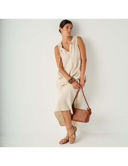 Platinum strap sandal with a small heel in leather color, perspective view in a general shot of the model leaning agai - MONPIEL Platinum strap sandal with a small heel in leather color, perspective view in a general shot of the model leaning agai - MONPIEL