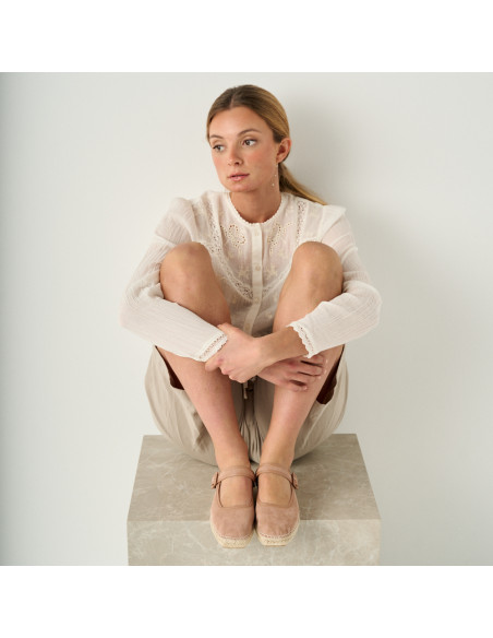 Espadrilla Cuba mercedita color rosa pallido con vista frontale, modello seduto su un cubo di marmo con i piedi appogg - MONPIEL Espadrilla Cuba mercedita color rosa pallido con vista frontale, modello seduto su un cubo di marmo con i piedi appogg - MONPIEL