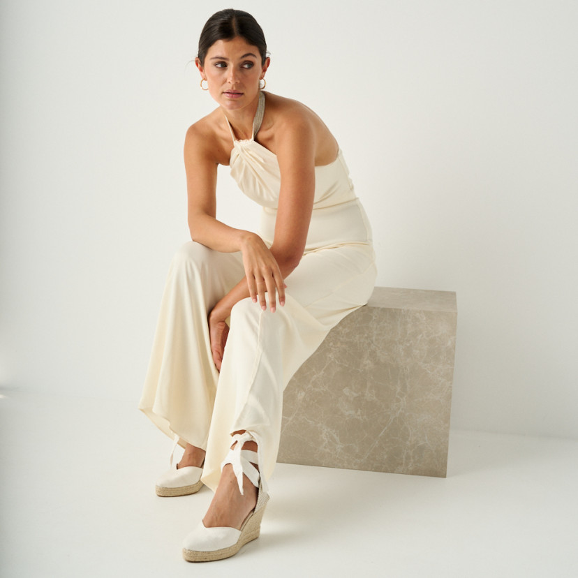 Espadrilha Elba seda noiva na cor branca com vista em perspectiva, plano geral do modelo sentada em cubo de mármore - MONPIEL