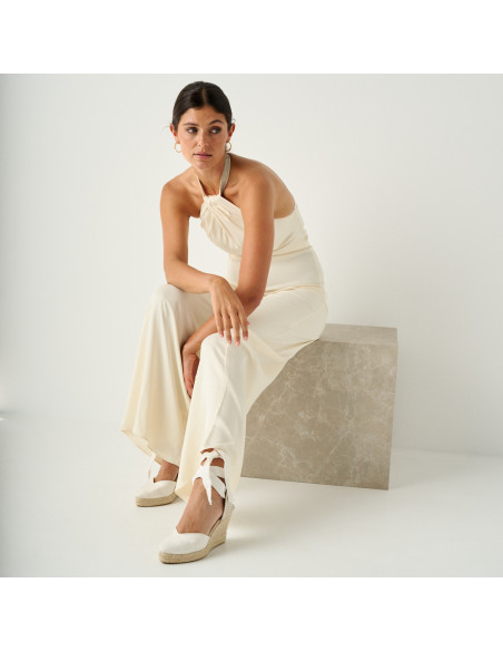White Elba silk bridal espadrille with a perspective view, general shot of the model sitting on a marble cube - MONPIEL White Elba silk bridal espadrille with a perspective view, general shot of the model sitting on a marble cube - MONPIEL