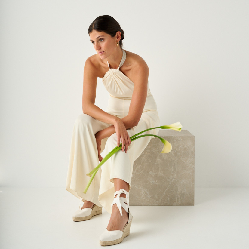 Espadrilha Elba seda noiva na cor branca com vista em perspectiva, plano geral do modelo sentada em cubo de mármore co - MONPIEL