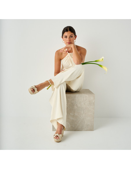 Lyra wedge espadrille with knot in platinum with front view, crossed leg in full shot - MONPIEL Lyra wedge espadrille with knot in platinum with front view, crossed leg in full shot - MONPIEL