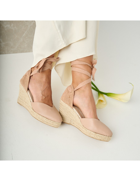 Espadrilha de cuña Elba de couro na cor nude, pés inclinados em primeiro plano com detalhe da flor - MONPIEL Espadrilha de cuña Elba de couro na cor nude, pés inclinados em primeiro plano com detalhe da flor - MONPIEL